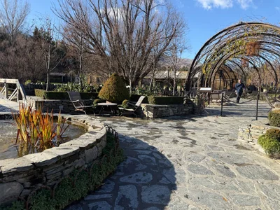 Stone courtyard and vine-covered pergola at Ayrburn near Arrowtown