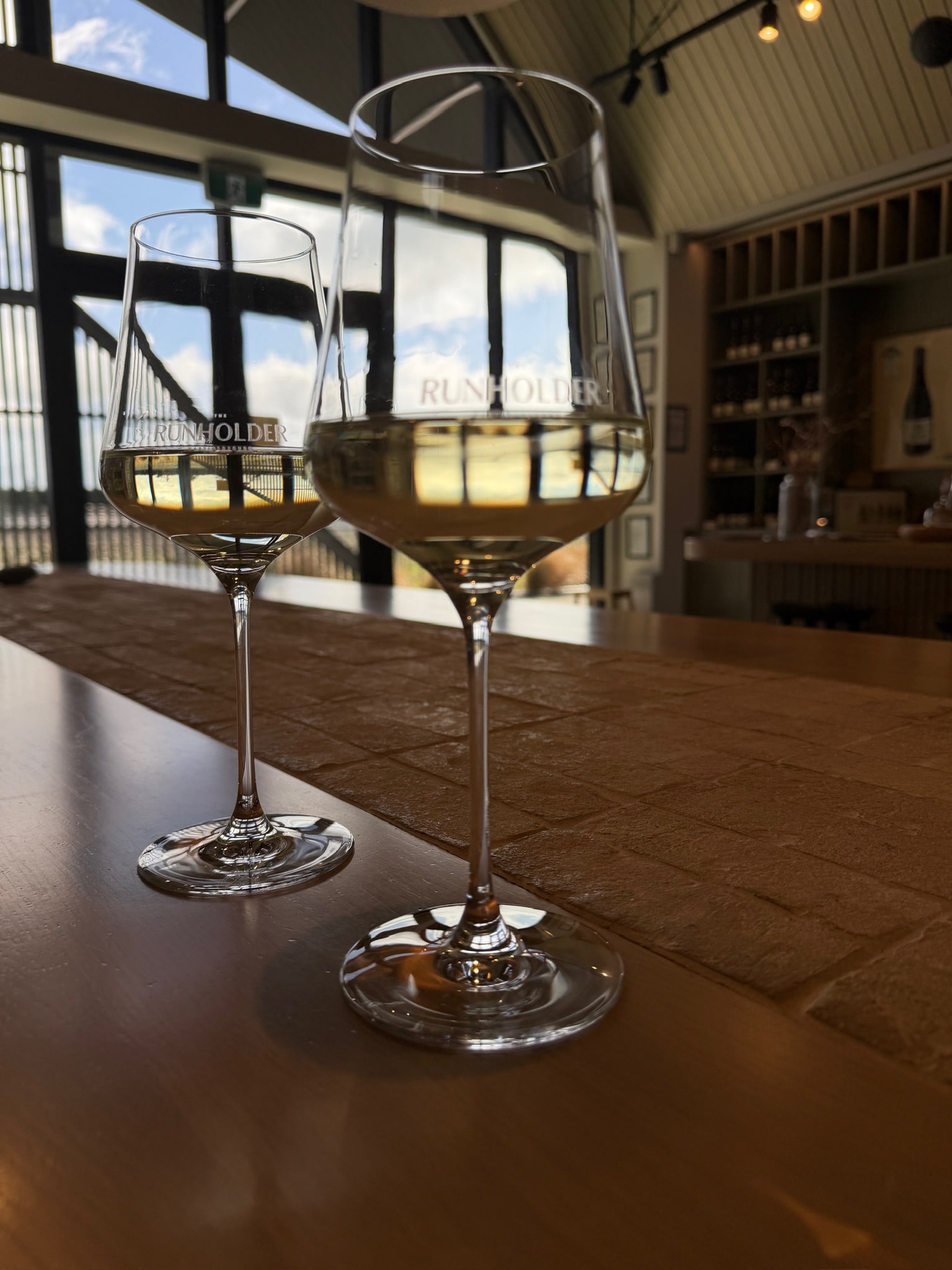 Two glasses of white wine on a wooden table at a winery