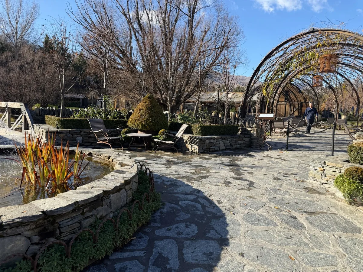 Stone courtyard and vine-covered pergola at Ayrburn near Arrowtown