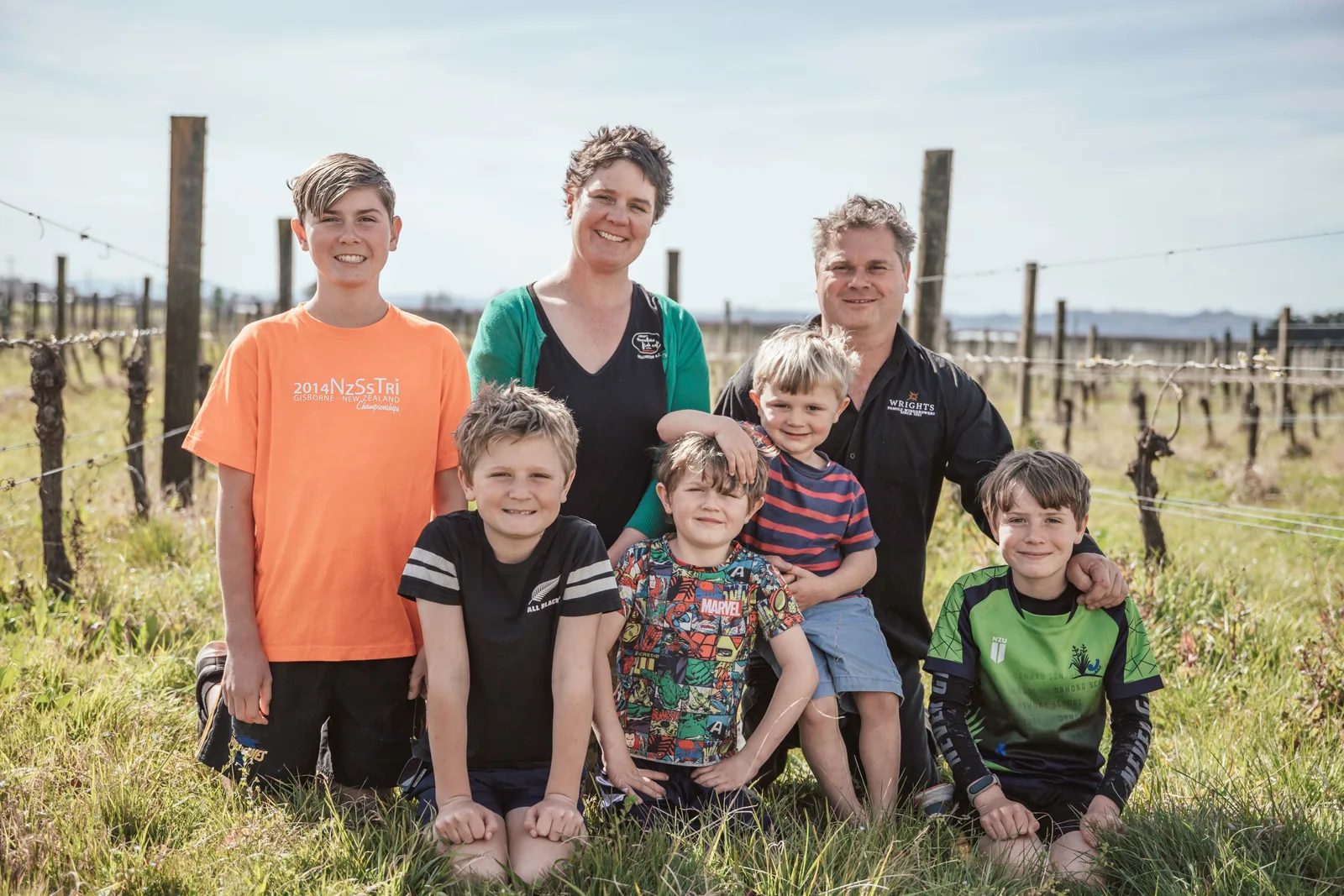 A family group standing among the vines at Wrights Vineyard