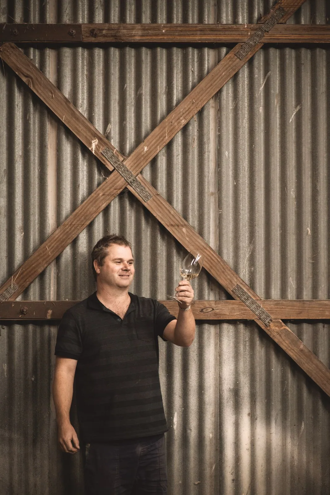 A person standing by timber doors at Wrights Vineyard